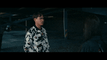 a man and a woman are looking at each other with a motorcycle in the background