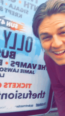 a man is smiling in front of a sign that says yijo