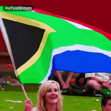 a woman is holding a south african flag and smiling at the camera