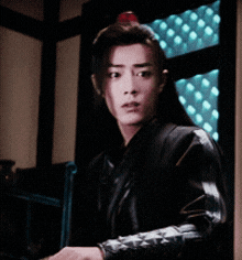 a man in a black jacket is standing in a room