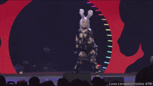 a woman in a bunny costume stands on a stage in front of a screen that says luna lorraine on it