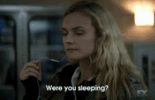 a woman is holding a fork in her mouth while wearing headphones and asking if she is sleeping .