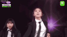 a woman in a suit and tie is performing on stage .