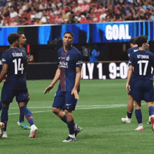 a group of soccer players are on a field and one has the number 14 on his shirt