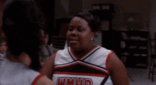 two cheerleaders are giving each other a high five in front of a crowd