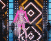 a woman in a pink dress and thigh high boots is standing on a stage