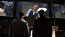two men in suits and ties are standing next to each other and one has a name tag on his chest that says ' james '
