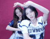 two girls wearing cowboys jerseys are posing for a photo