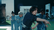 a group of people are dancing and one of them is pointing at the camera