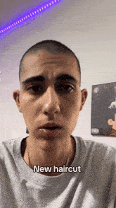 a man with a shaved head says " new haircut " in a video