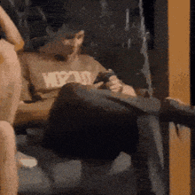 a man sitting on a couch wearing a shirt that says wpd on it