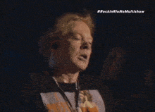 a man singing into a microphone with the hashtag #rockinrionomultishow on the bottom