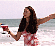 a woman in a red and white plaid dress holds a margarita
