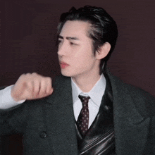 a man in a suit and tie is holding a microphone in his hand .