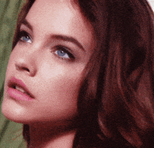 a close up of a woman 's face with blue eyes and red hair