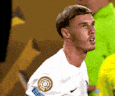 a soccer player wearing a white shirt with a fifa logo on his sleeve