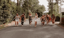 a group of barefoot women are running down a road