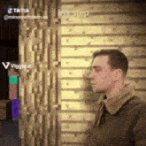 a man is standing in front of a brick wall with a tiktok watermark on it