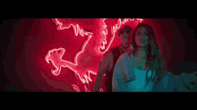 a man and a woman are standing in front of a neon sign that says ' between '