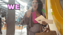 a woman holding a piece of paper with the word we above her head
