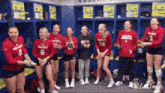 a group of female volleyball players are laughing in the locker room