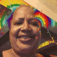a woman with a rainbow in her hair is smiling
