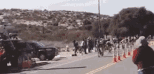 a group of people are riding bikes down a street .