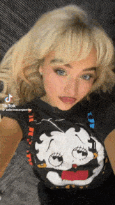 a woman with blonde hair is wearing a black t-shirt with a bee face on it