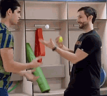 two men are standing in a locker room and one of them is wearing a shirt that says ' eh ' on it