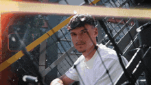 a man in a white shirt sits on a staircase looking at the camera
