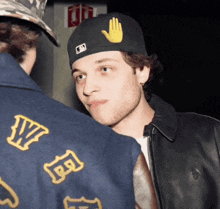 a man wearing a hat with a yellow hand on it