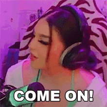 a woman wearing headphones is sitting in front of a microphone and says come on .
