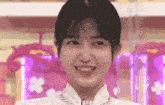 a young woman is smiling and looking at the camera .