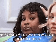 two women are sitting next to each other and one of them is holding her hand to her head .