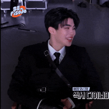 a man in a suit and tie is sitting in a chair with a sticker that says pisoje on it