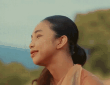 a woman with her hair in a ponytail looks to the side