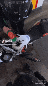 a man is pumping gas into a motorcycle that has a tiktok watermark on it
