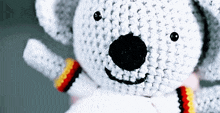 a close up of a crocheted teddy bear with black eyes