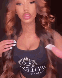 a woman wearing a black crop top with a crown on it is taking a selfie .