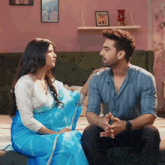 a man and a woman are sitting on a couch and talking