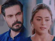 a man with a beard and a woman with a ponytail look at each other