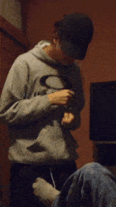 a man wearing an oakley hoodie adjusts his pants