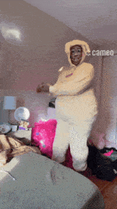 a person wearing a cameo hoodie is dancing on a bed