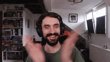 a man wearing headphones and a green shirt is clapping