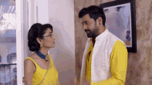 a man and a woman are standing next to each other and looking at each other .