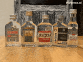 several bottles of vodka are lined up on a wooden table