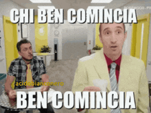 two men are sitting at a table and one of them is wearing a yellow suit and tie