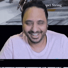 a man in a pink shirt is smiling in front of a screen that says " pet string "