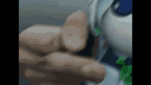 a close up of a person 's hand holding a green object .