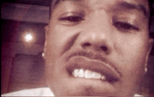 a close up of a man 's face with his mouth open and his teeth visible